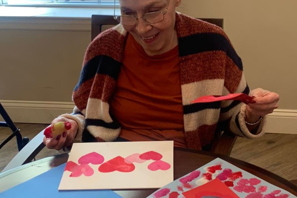 A resident showing their valentines crafts at Harmony Senior Services