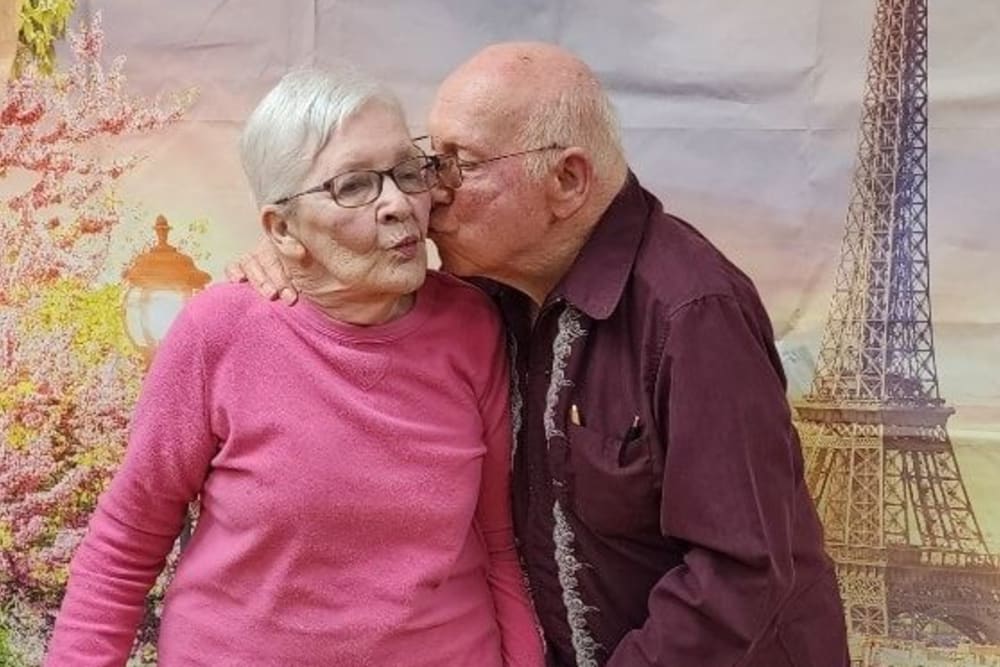 A resident kissing their wife on the cheek at Harmony Senior Services