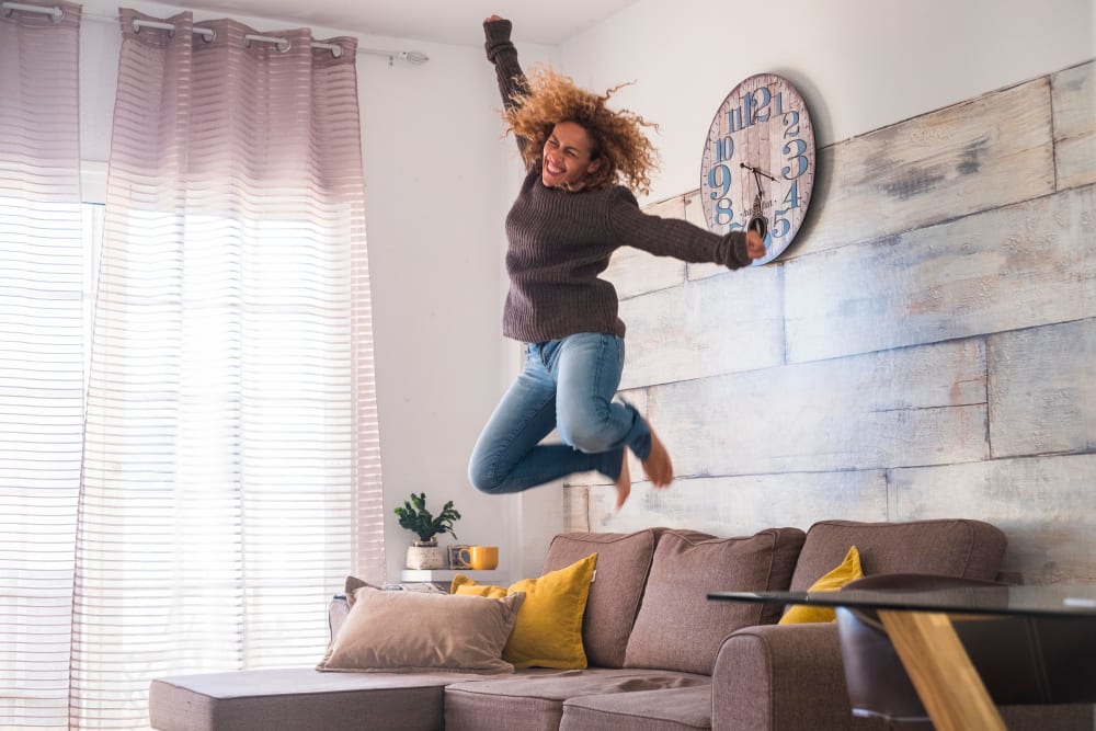 Woman jumping with excitement at Madison Park Apartments in Bothell, Washington