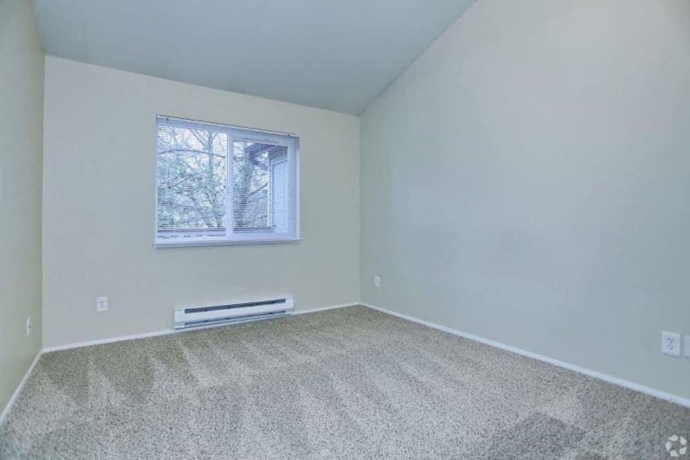 Bedroom with a window at Madison Park Apartments in Bothell, Washington