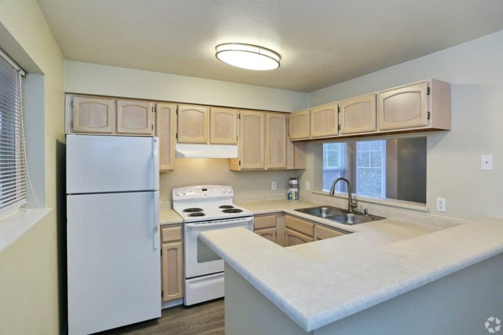 Kitchen with wooden cabinets at Madison Park Apartments in Bothell, Washington