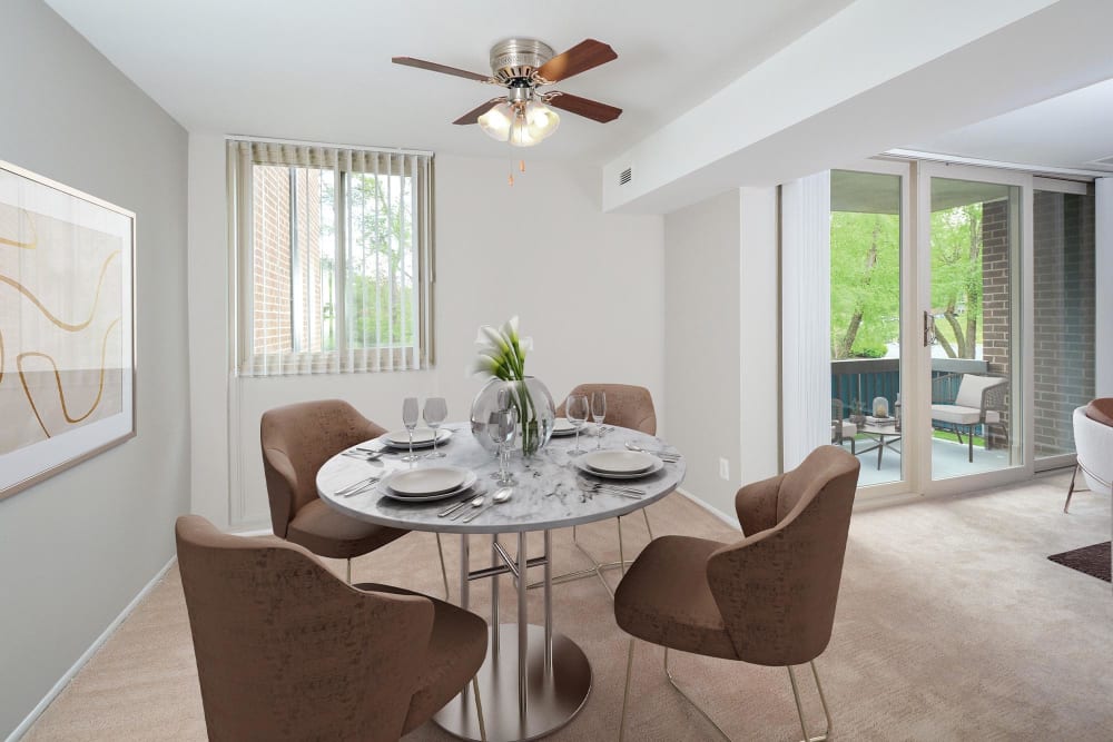Dining area with a ceiling fan in a model apartment home at Landmark Glenmont Station in Silver Spring, Maryland
