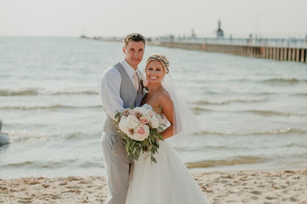 Couple posing on the beach at The Whitcomb Senior Living Tower in St. Joseph, Michigan