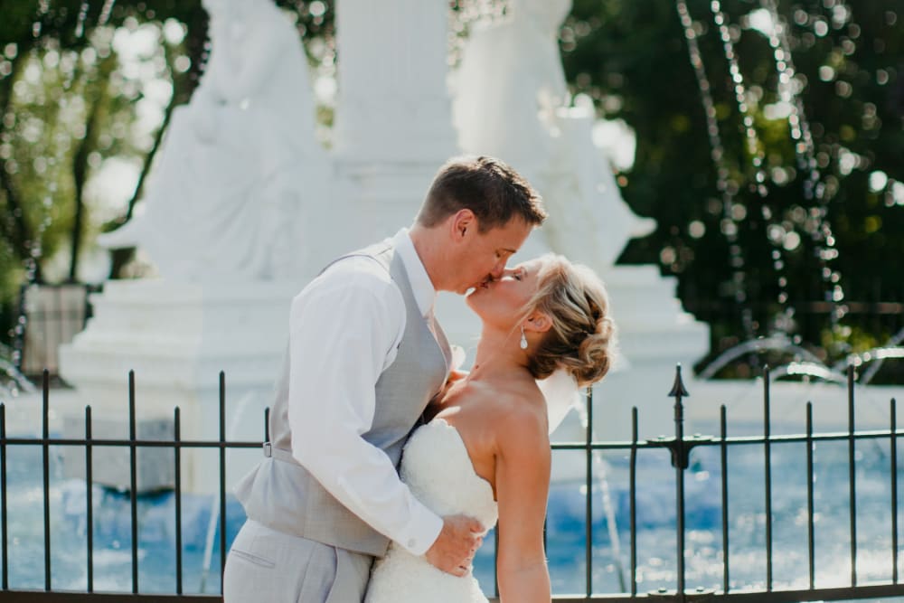 Couple kissing in front of a fountain at The Whitcomb Senior Living Tower in St. Joseph, Michigan