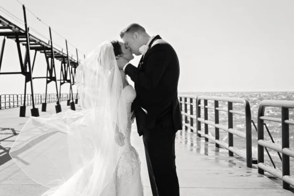 Couple kissing by the water at The Whitcomb Senior Living Tower in St. Joseph, Michigan