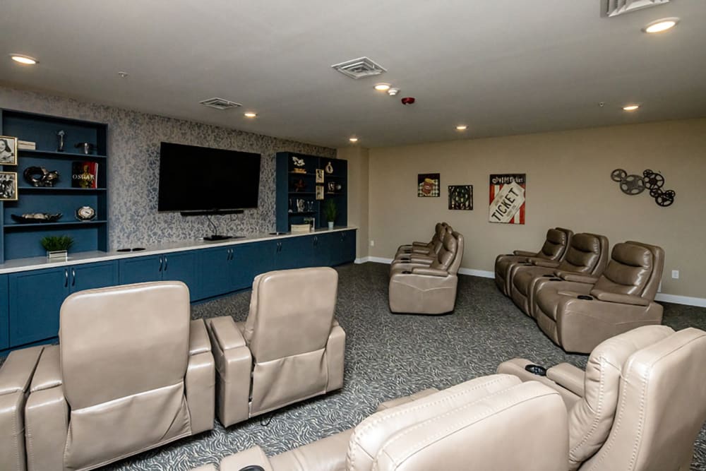 Resident movie theater and recreation room with large television and leather armchairs at The Views at Lake Havasu in Lake Havasu City, Arizona