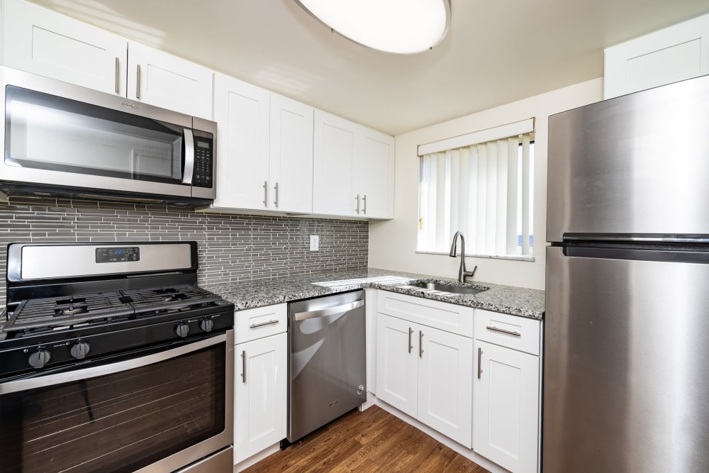 upgraded kitchen with white cabinets and stainless steel appliances