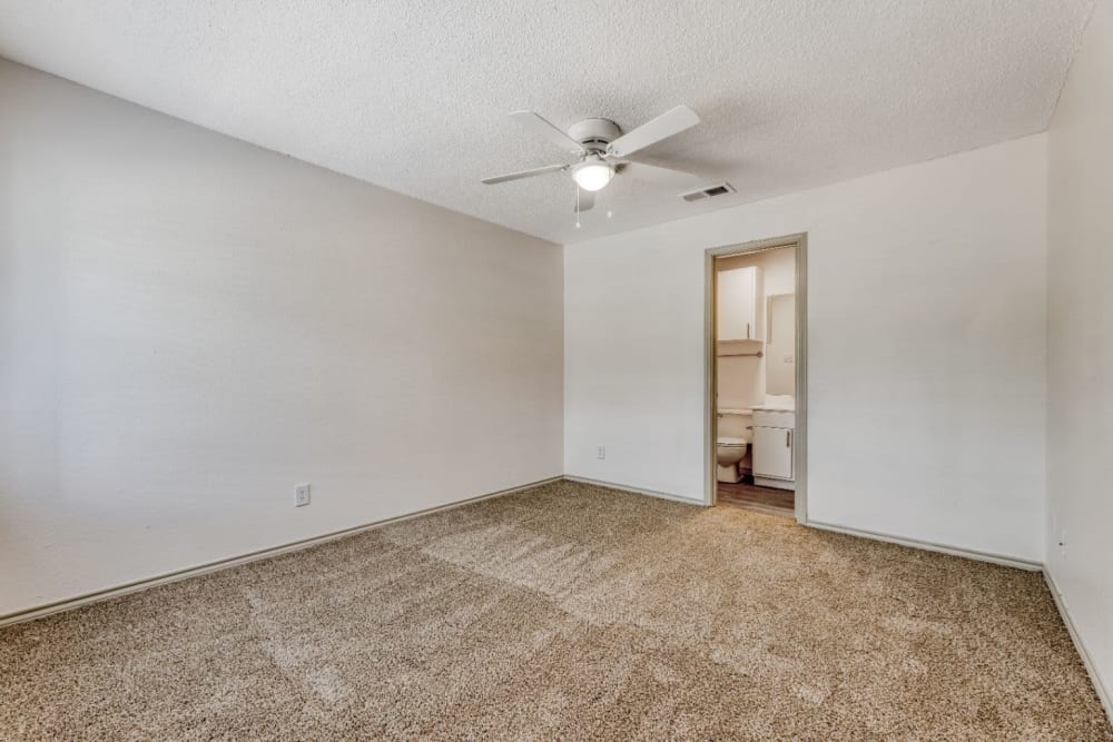 Unfurnished bedroom space with carpeted flooring and ceiling fan at Marshall Apartment Homes in Balch Springs, Texas