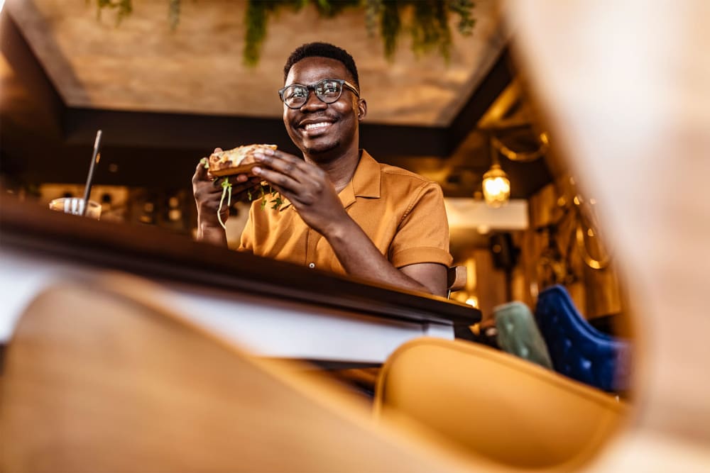 Resident enjoying a burger at a restaurant near our Rafael Gardens community at Mission Rock at Novato in Novato, California