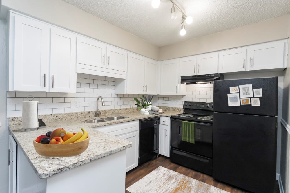 Kitchen with black appliances and wood cabinets at Parkview Flats Apartments in Murfreesboro, Tennessee