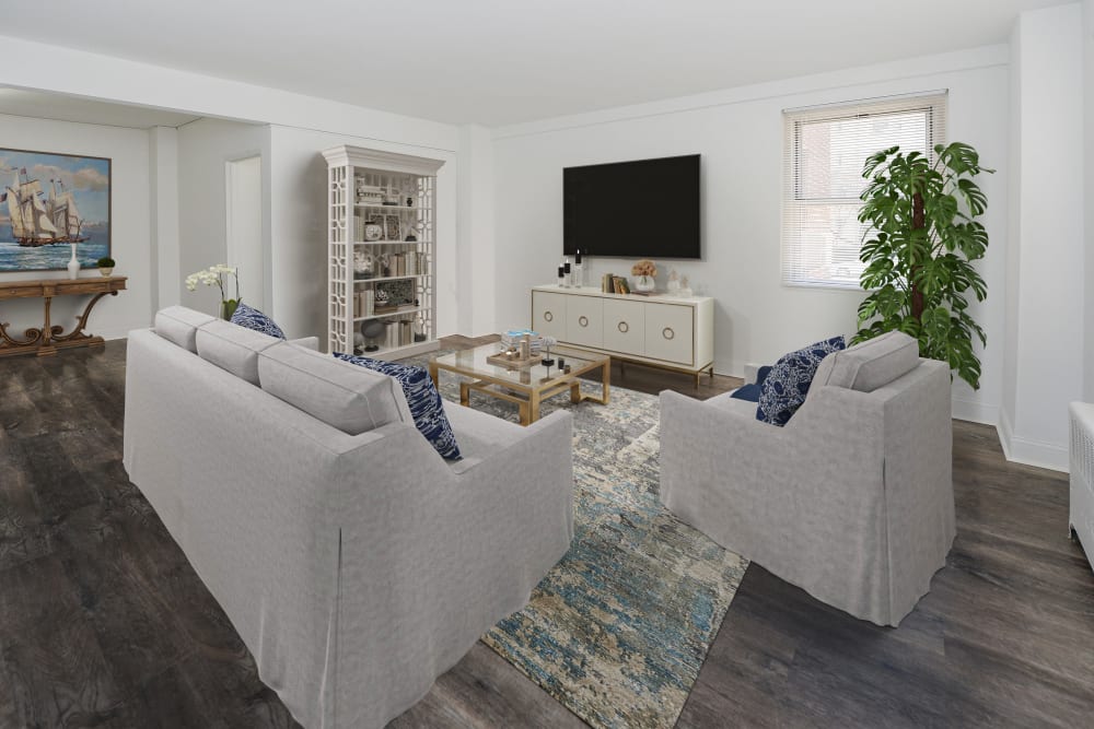 Staged living room and dining area in renovated home with hardwood style flooring