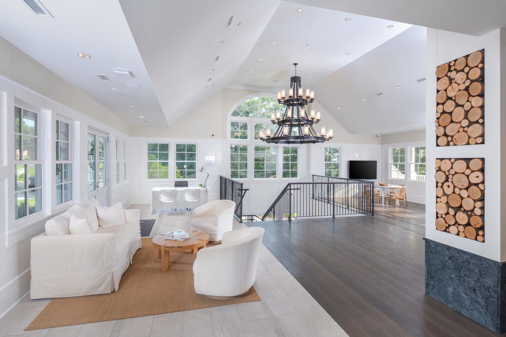 Community Clubhouse with white couches dark hardwood floors at Overlook at Flanders, Flanders, New Jersey