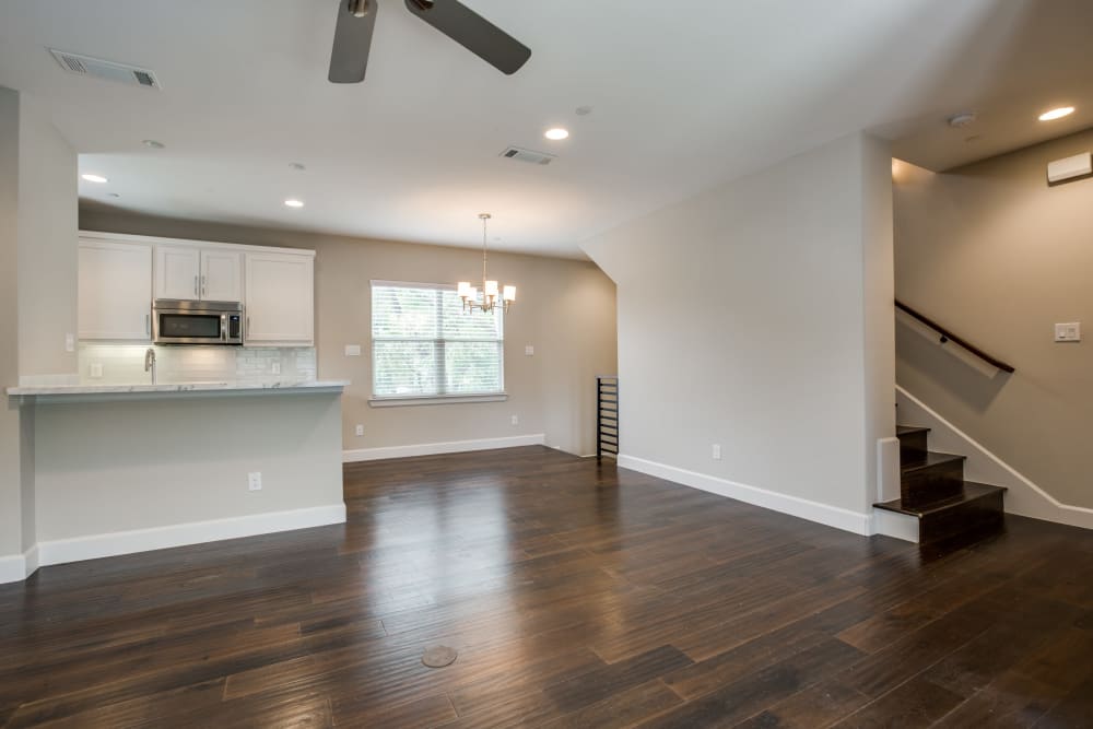 Open concept living area with hardwood floors and ceiling fan at The Collection Townhomes in Dallas, Texas