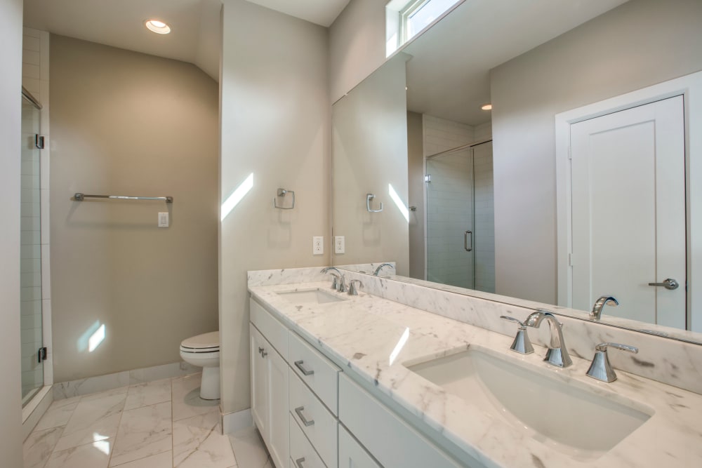 Full bathroom with double sink vanity at The Collection Townhomes in Dallas, Texas