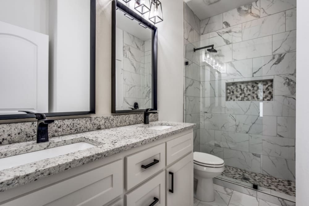 Bathroom with double vanity and shower at The Collection Townhomes in Dallas, Texas