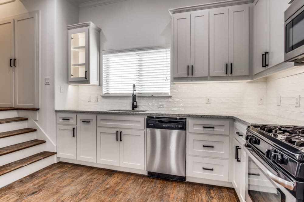 Modern kitchen with full appliances and hardwood floors at The Collection Townhomes in Dallas, Texas