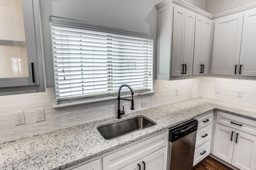 Modern kitchen with granite counters and stainless steel sink at The Collection Townhomes in Dallas, Texas