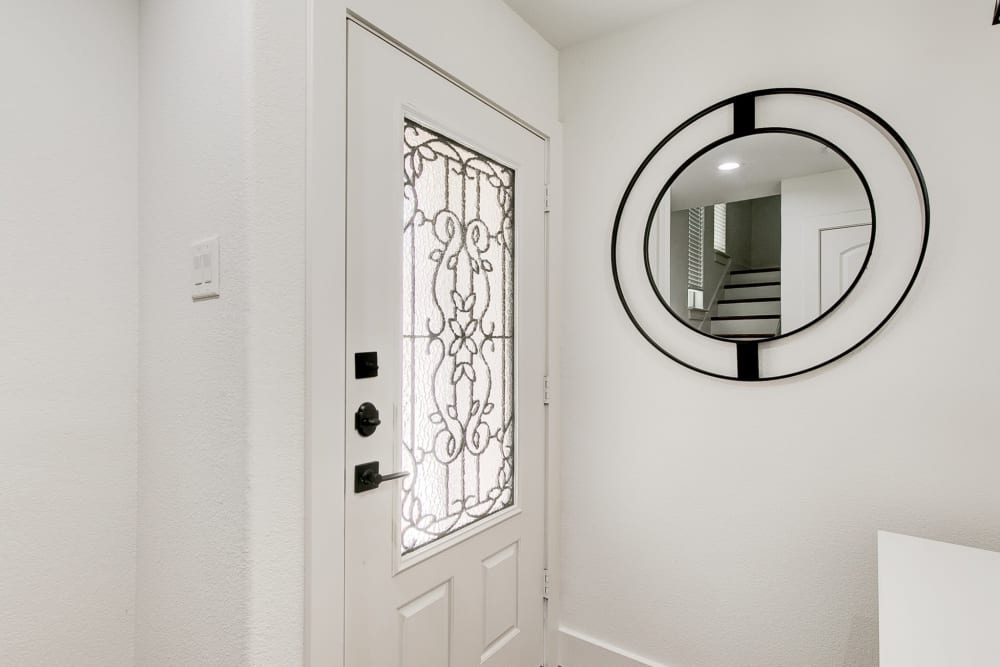 Front door and round artistic mirror on the wall of townhome at The Collection Townhomes in Dallas, Texas