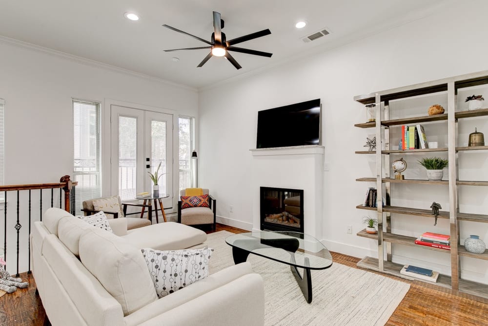 Furnished living room with large television and bookshelf at The Collection Townhomes in Dallas, Texas