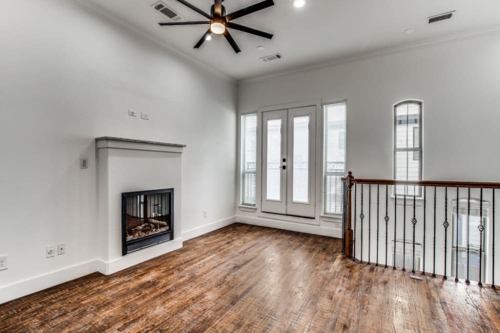 Spacious living room with fireplace and ceiling fan at The Collection Townhomes in Dallas, Texas