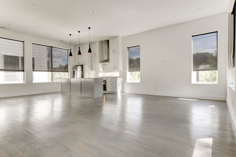 Spacious open concept living area with gray hardwood floors and multiple windows at The Collection Townhomes in Dallas, Texas