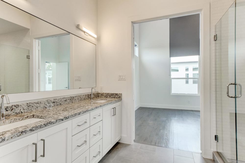 Large bathroom with granite countertops and large mirror at The Collection Townhomes in Dallas, Texas