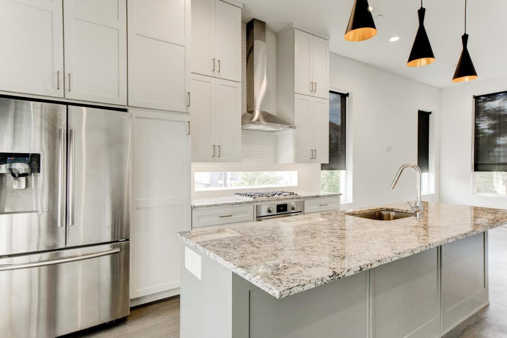 Large kitchen with granite countertops and stainless steel fridge at The Collection Townhomes in Dallas, Texas