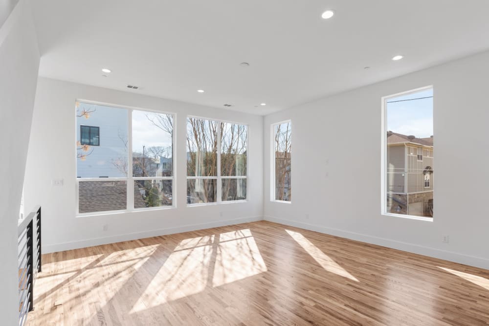 Spacious living room with large windows and hardwood floors at The Collection Townhomes in Dallas, Texas