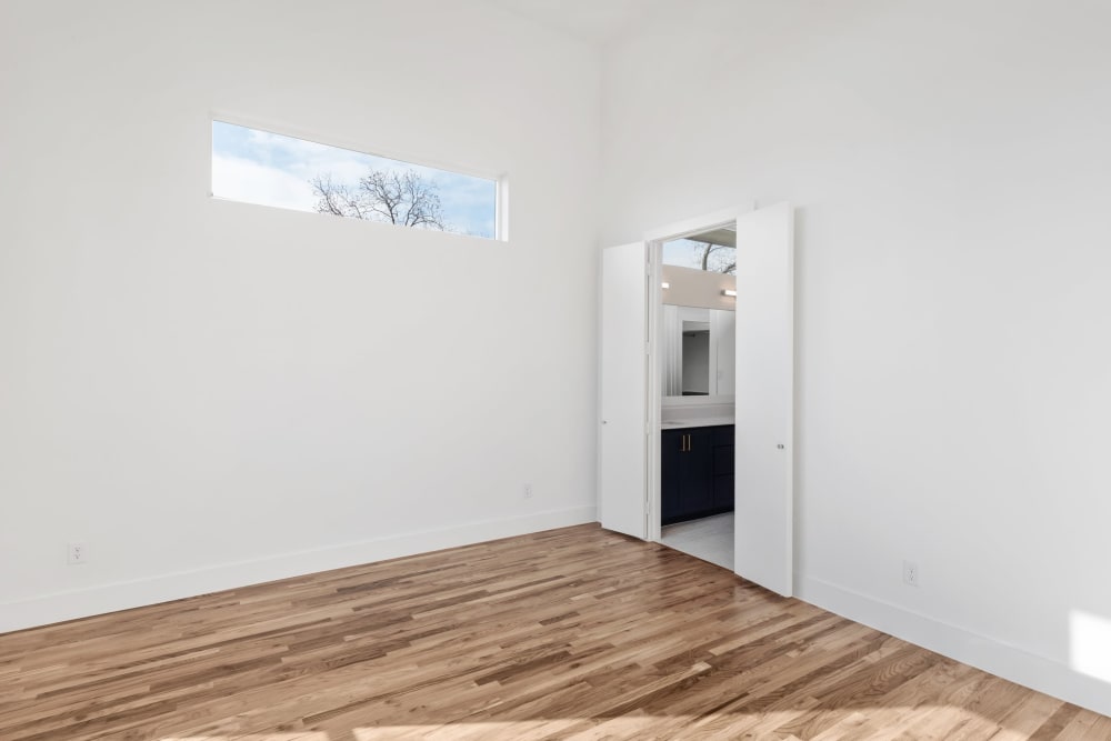 Large room with hardwood floors leading to private bathroom at The Collection Townhomes in Dallas, Texas