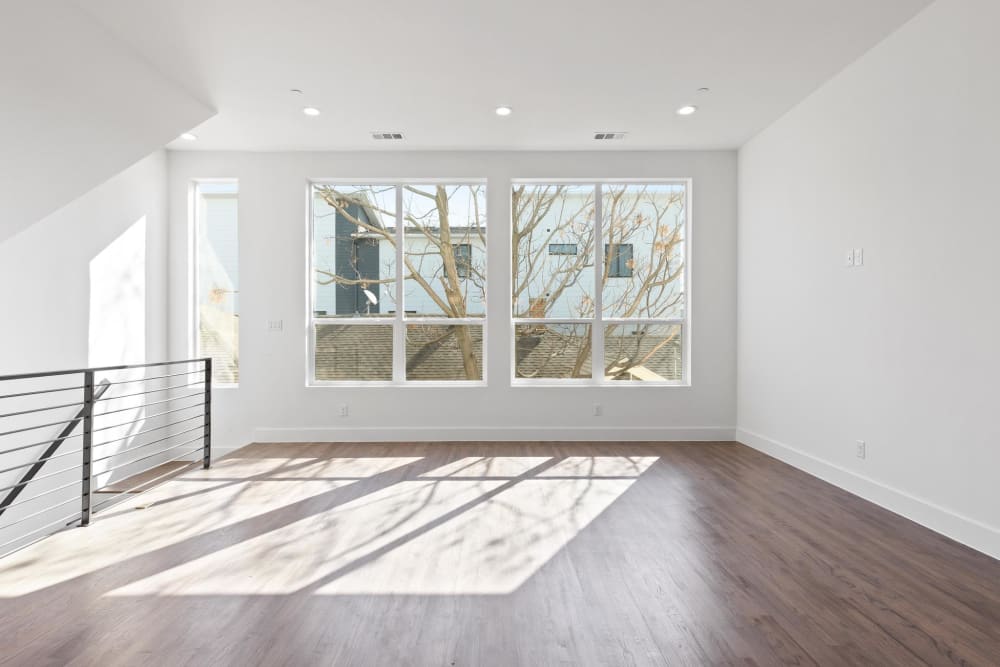 Spacious room with hardwood floors and multiple sunlit windows at The Collection Townhomes in Dallas, Texas