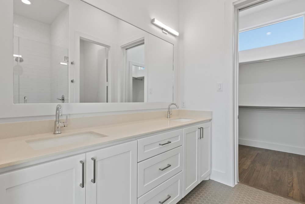 Large bathroom with double vanity sinks and large mirror at The Collection Townhomes in Dallas, Texas