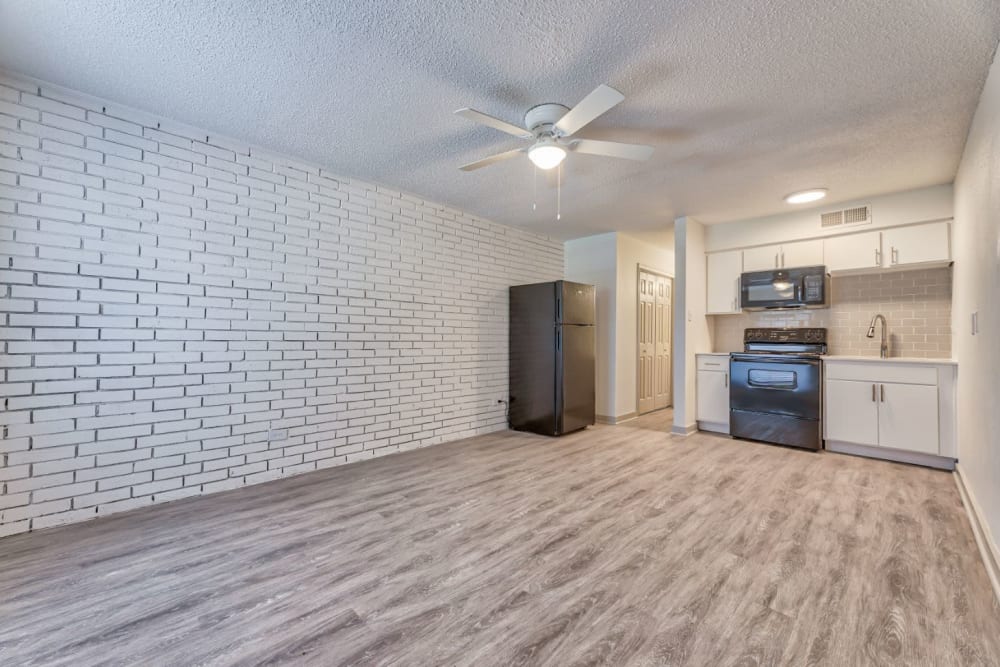 Spacious living room leading to a furnished kitchen at Lovato Apartment Homes in Garland, Texas
