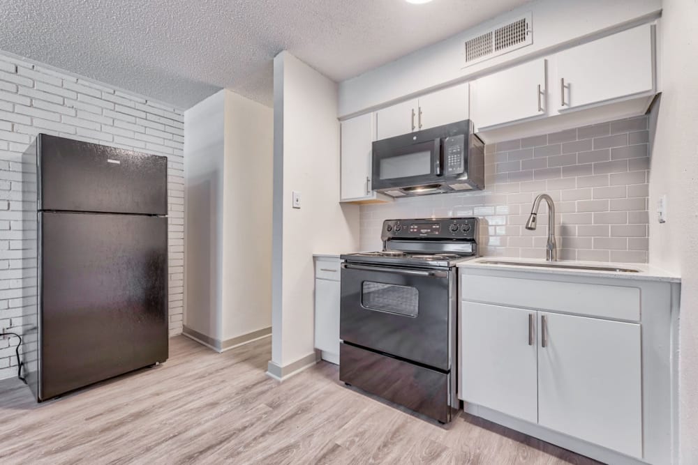 Kitchen with modern amenities at Lovato Apartment Homes in Garland, Texas
