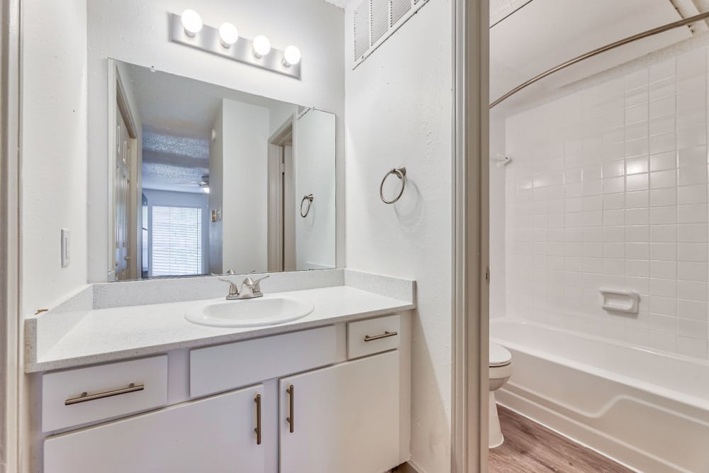 Beautiful bathroom vanity and bathtub at Lovato Apartment Homes in Garland, Texas