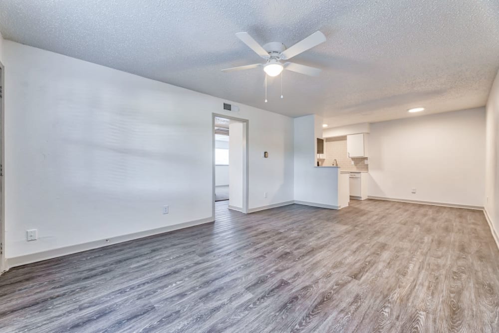 Unfurnished living room space with ceiling fan and hardwood floors at Lovato Apartment Homes in Garland, Texas