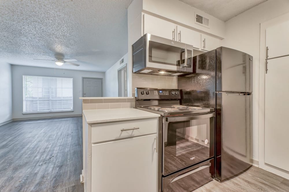 Kitchen leading directly to a spacious living room at Lovato Apartment Homes in Garland, Texas