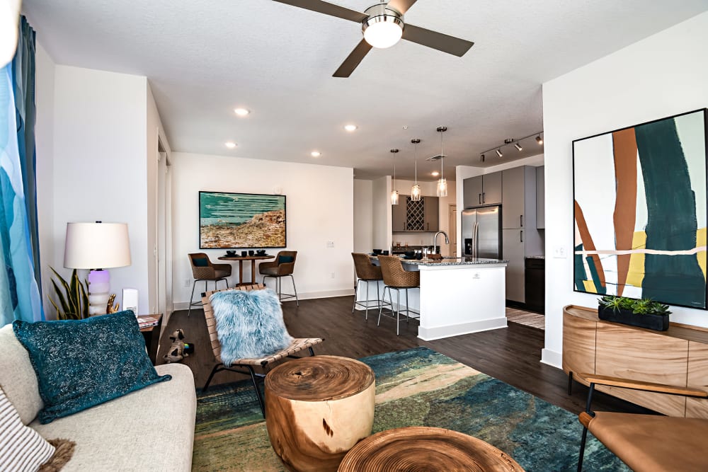 Beautiful living room and kitchen with plank flooring at Olympus Preserve at Town Center in Jacksonville, Florida