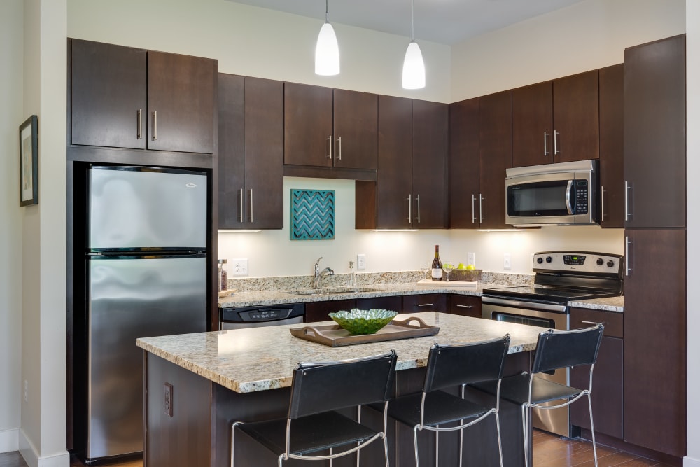 Model kitchen with dark wood cabinets at Arcadia at Rivers Edge in Medford, Massachusetts