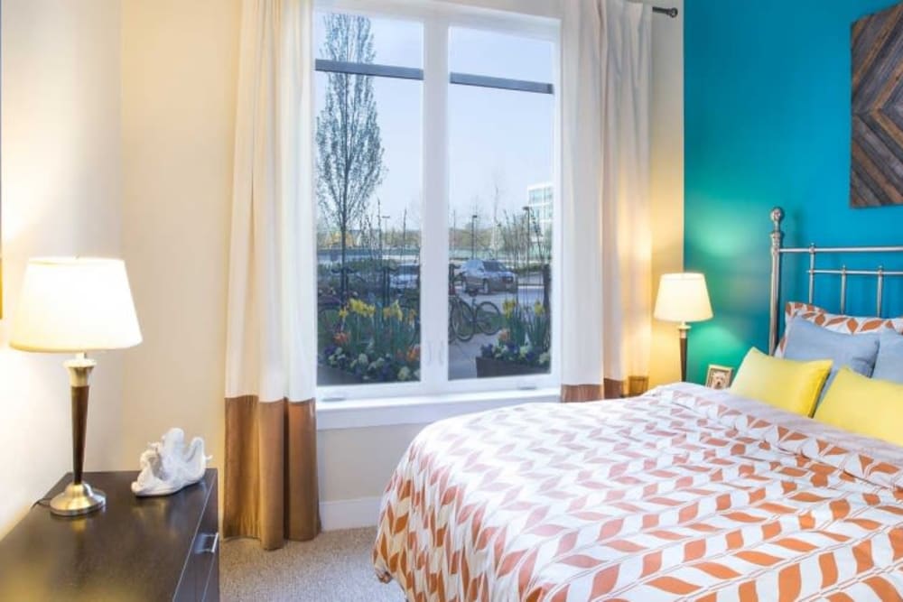 Model bedroom with large windows at Arcadia at Rivers Edge in Medford, Massachusetts