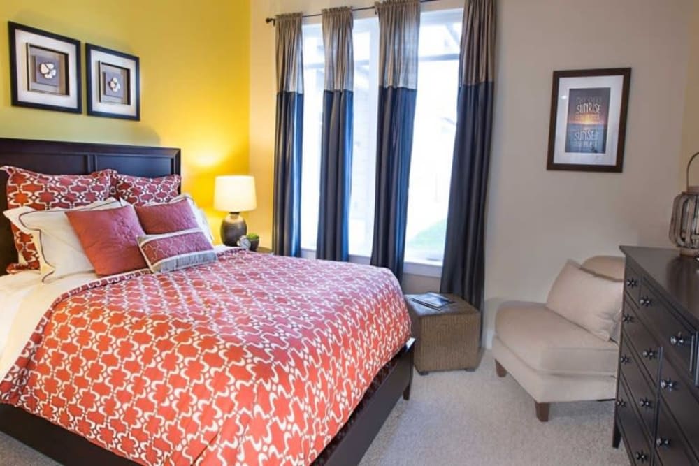 Model bedroom with a yellow accent wall at Arcadia at Rivers Edge in Medford, Massachusetts