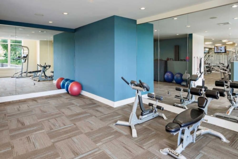 Resident gym with a large mirror at Arcadia at Rivers Edge in Medford, Massachusetts