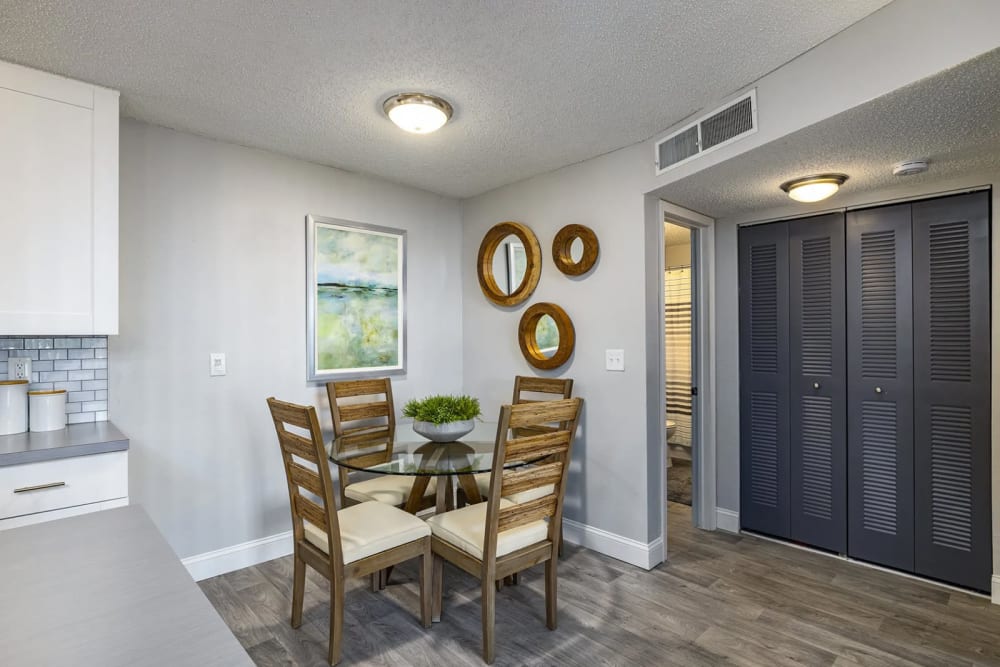 A dining room table next to a closet leading to a bathroom in a model home at The Delmar in Tampa, Florida
