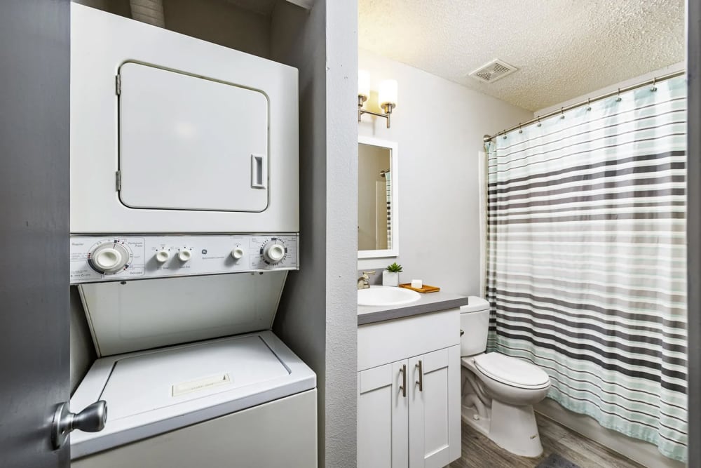 An upscale bathroom next to an in-home washer and dryer at The Delmar in Tampa, Florida