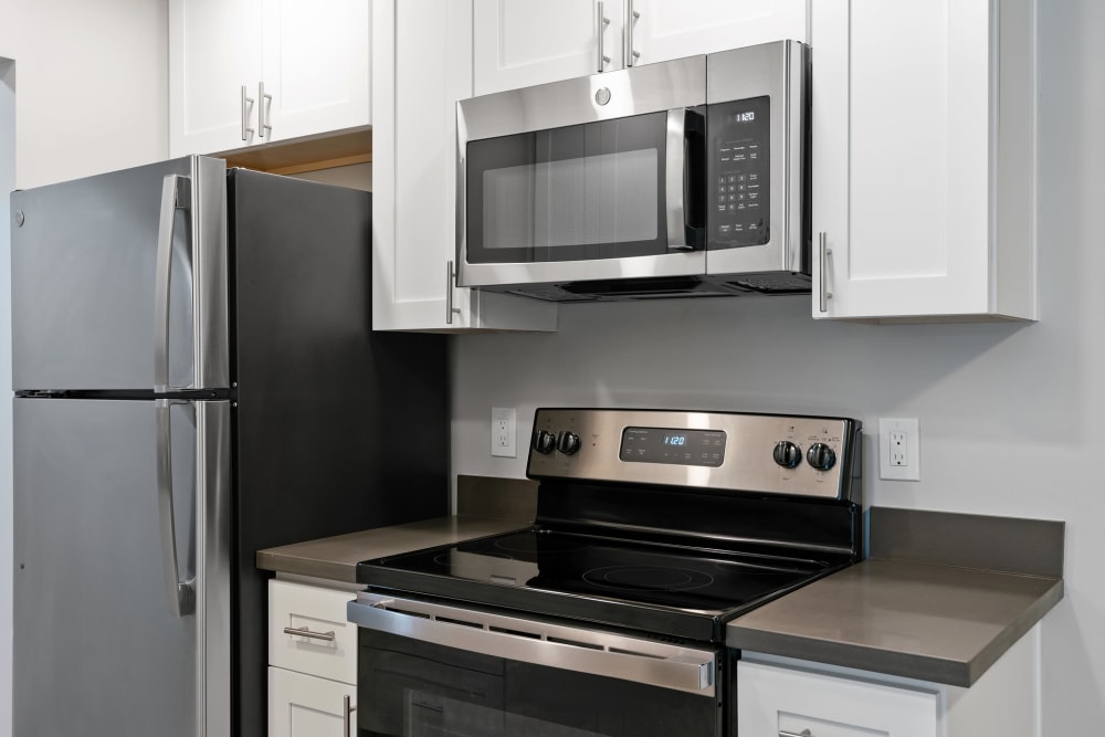 Kitchen with white cabinets and stainless appliances at Regency Plaza Apartments