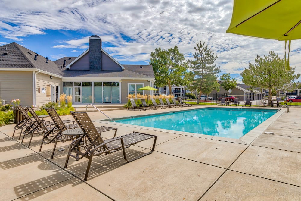 Lounge chairs by poolside at The Pines at Castle Rock Apartments in Castle Rock, Colorado