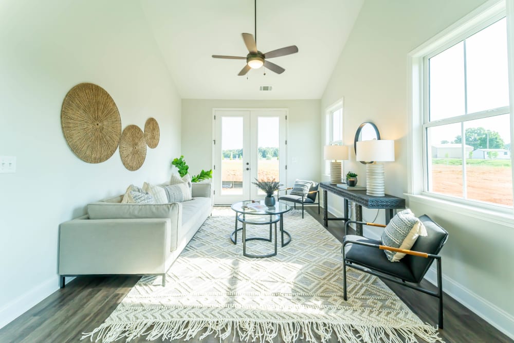 Brightly lit living room with ceiling fan at Baldwin Chase in Mauldin, South Carolina