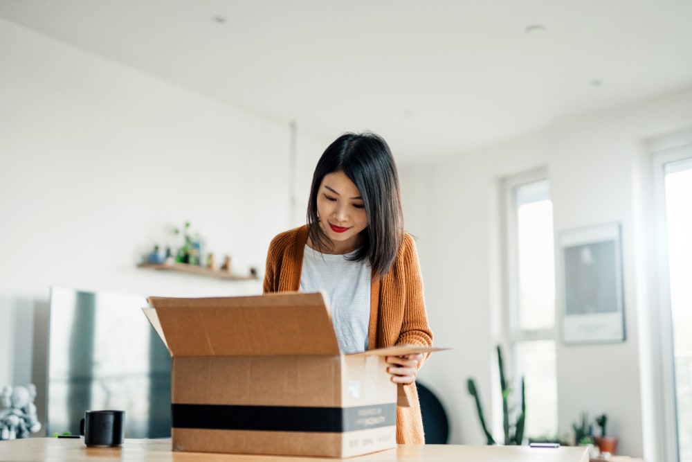 A woman opening a box near BestBox Storage - New Caney in New Caney, Texas