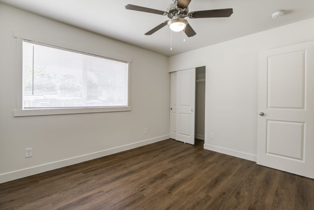Bedroom with ceiling fan, large window and closet at Heartwood in Joint Base Lewis McChord, Washington