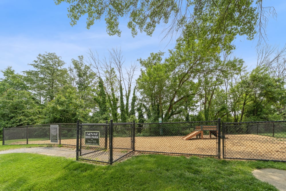 Fenced-in dog park with agility equipment at Satyr Hill Apartments in Parkville, Maryland