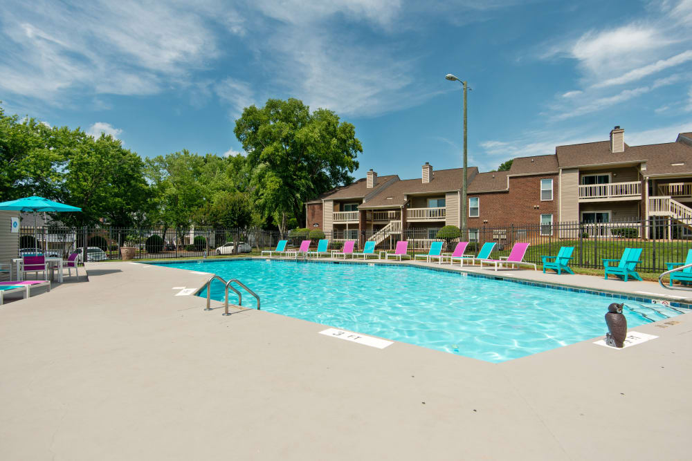 Beautiful blue Swimming Pool with Chaise Lounges at Devonwood Apartment Homes in Charlotte, North Carolina